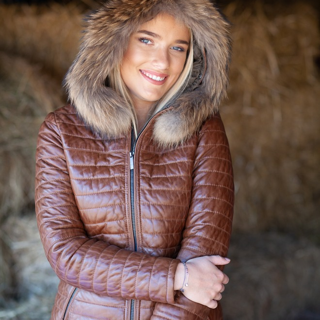 This women’s tan leather parka with natural raccoon fur trim